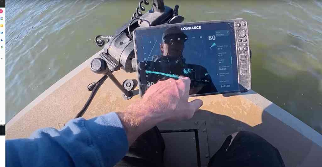 A sonar display on the boat reveals distinct fish marks at around 40 feet, indicating potential catfish below.